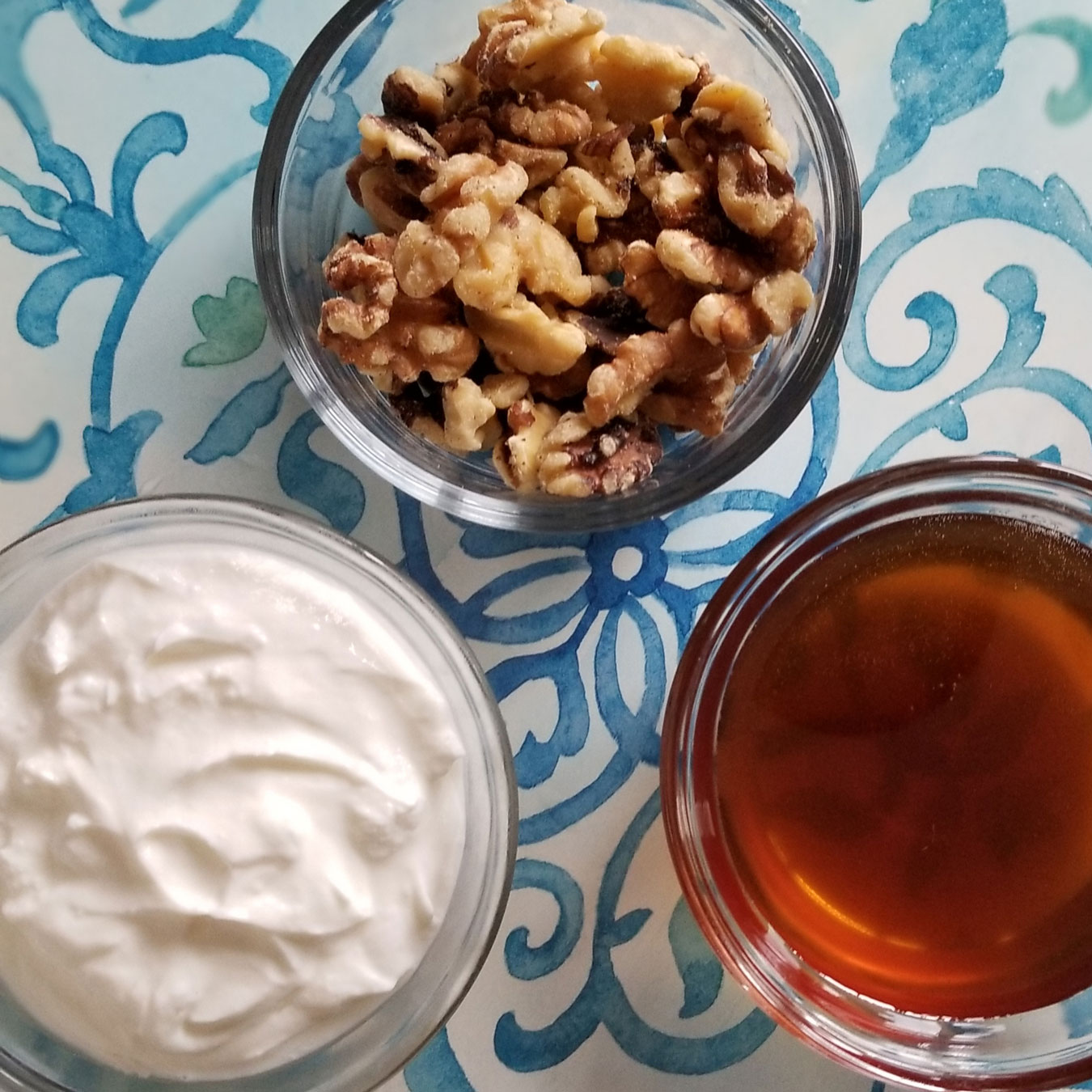 Greek yogurt, honey and walnuts in individual bowls