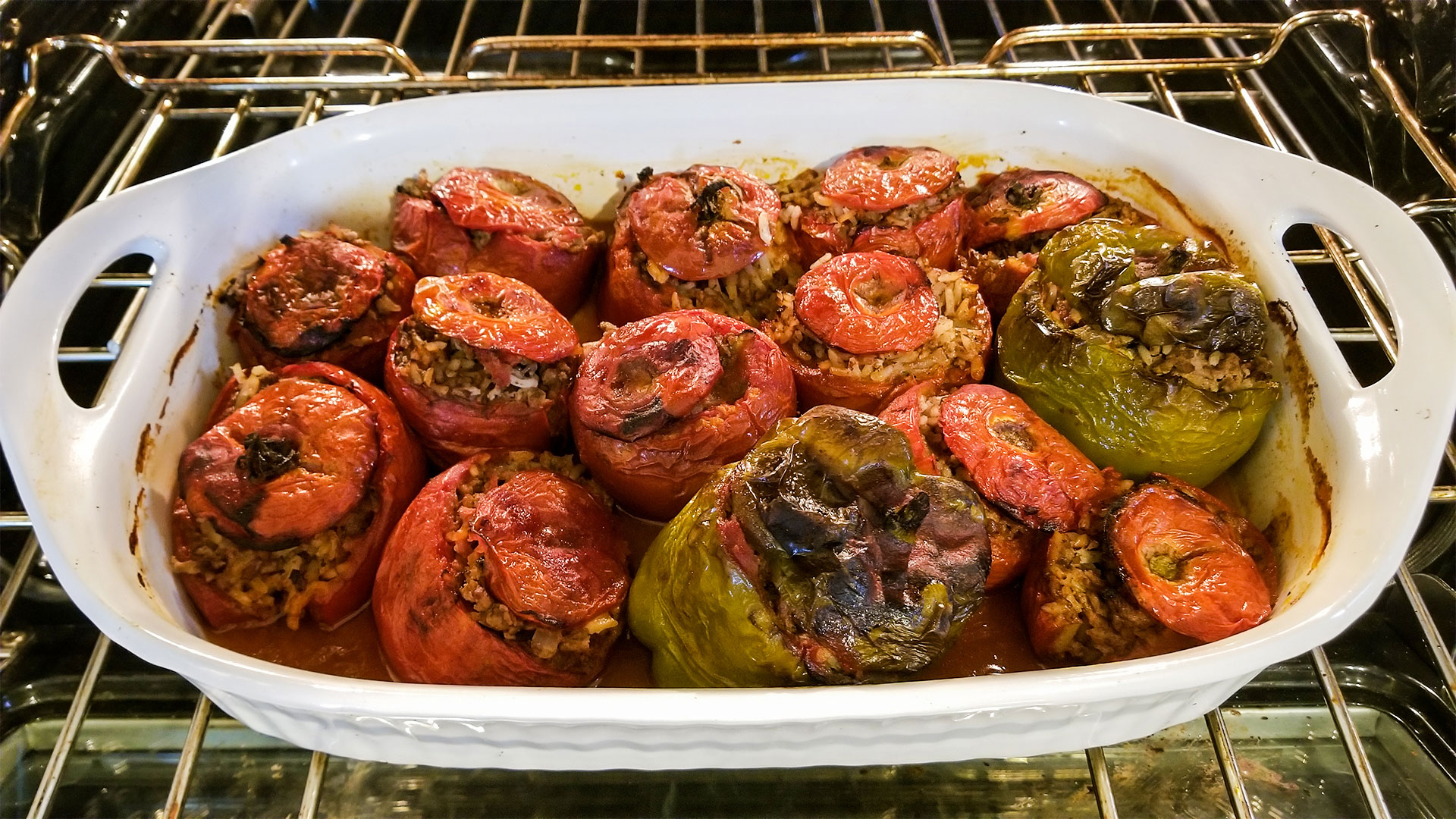 Yemista stuffed tomatoes and peppers cooking in the oven