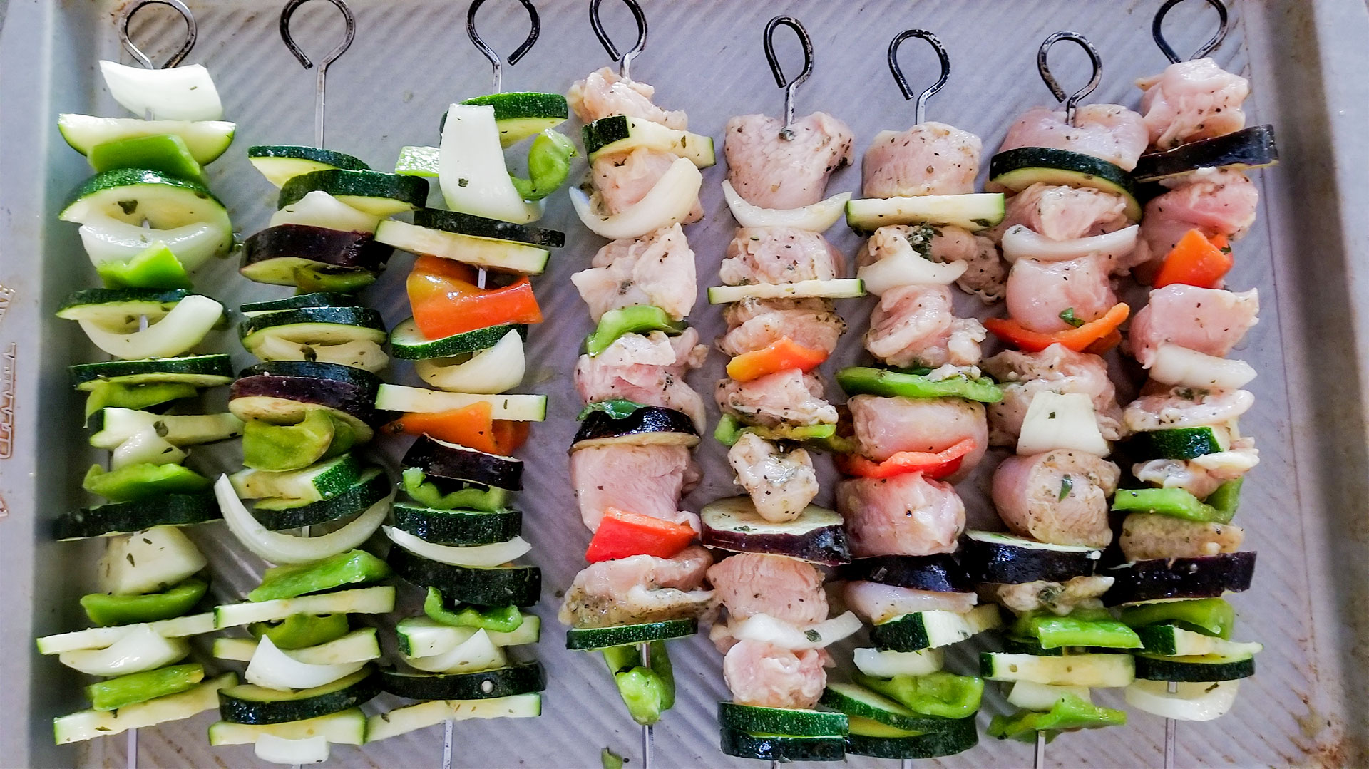 vegetable and chicken souvlaki kebabs on a sheet pan