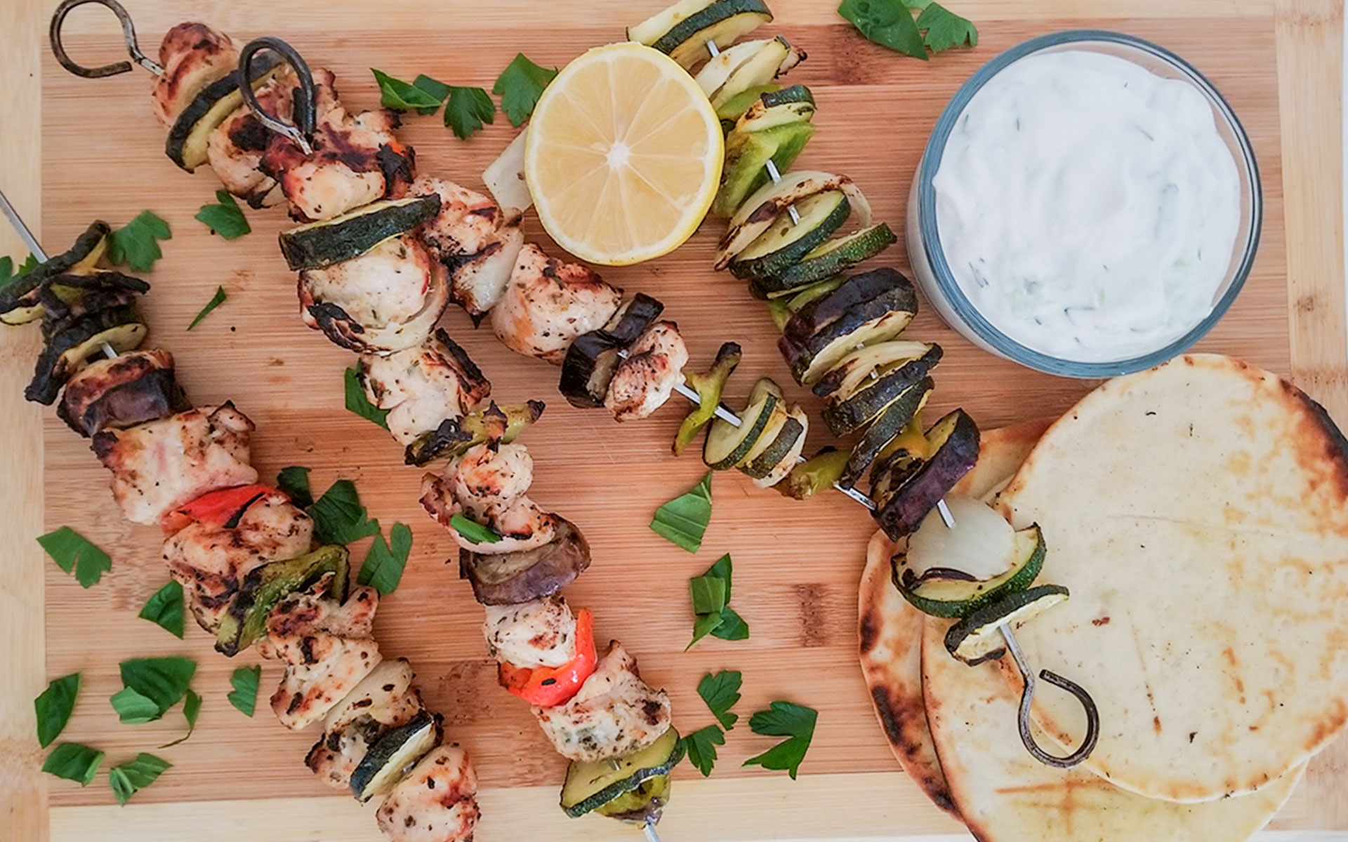 grilled chicken and vegetable souvlaki with tzatziki sauce and grilled pita bread