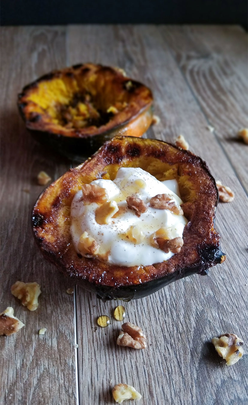 Baked acorn squash topped with greek yogurt and walnuts