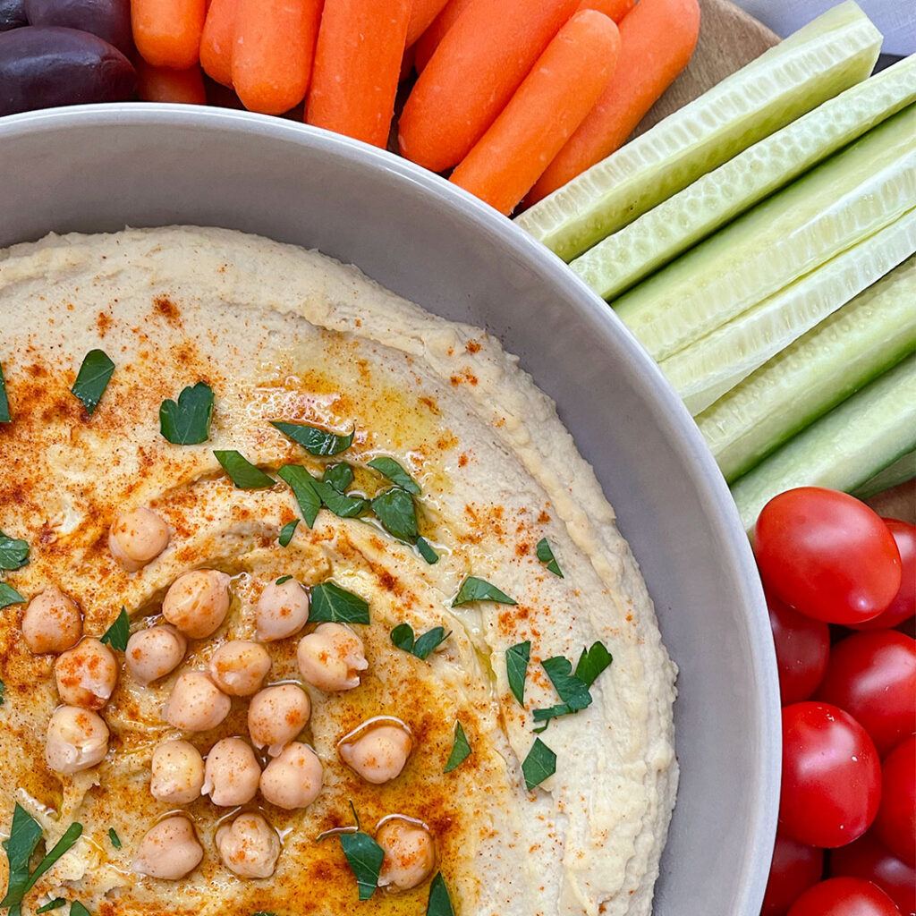 hummus topped with chickpeas, paprika, olive oil and parsley