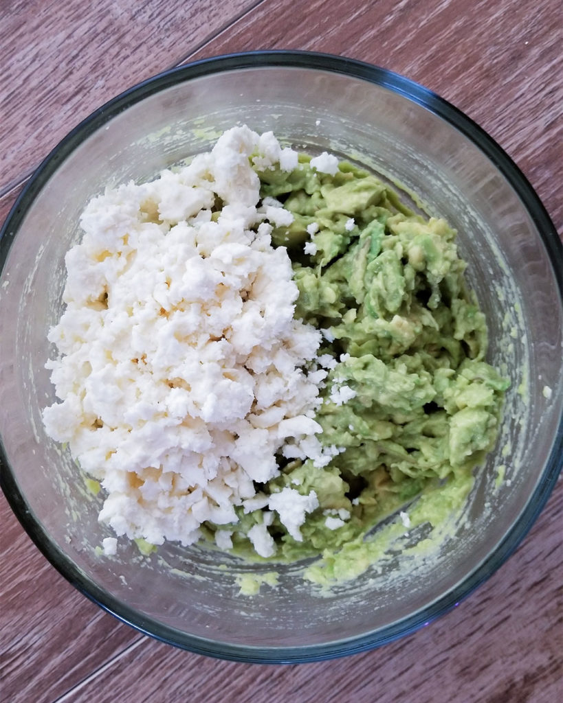 mashed avocados and feta cheese in a bowl