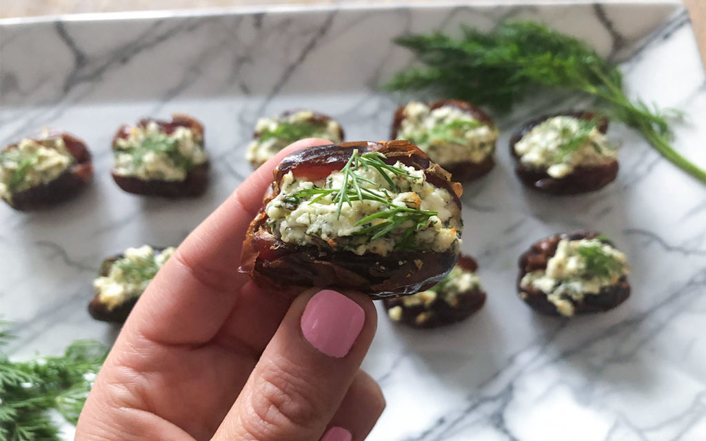 Feta Stuffed Dates arranged on a plate with fresh dill