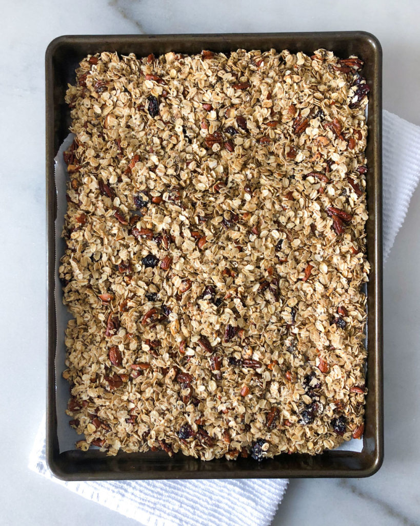 Heart Healthy Granola spread out on a parchment lined baking sheet
