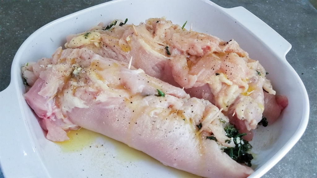 raw chicken with spanakopita filling in a baking diah
