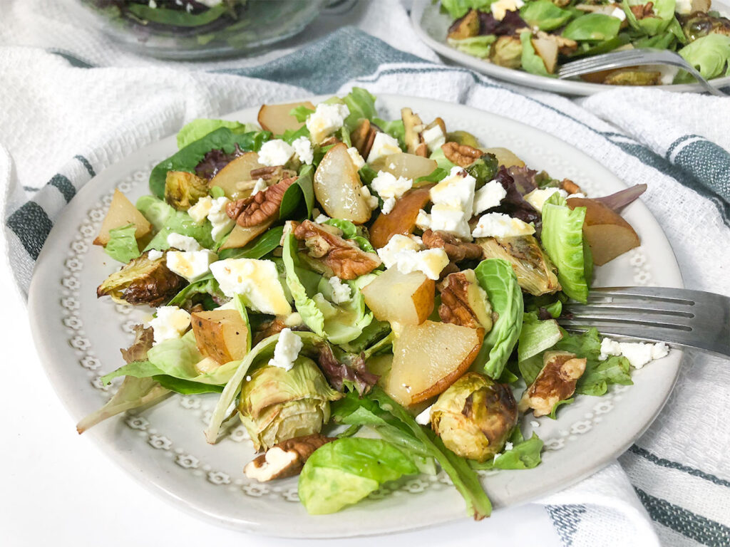 Brussels Sprout & Pear Salad topped with feta cheese and Dijon dressing