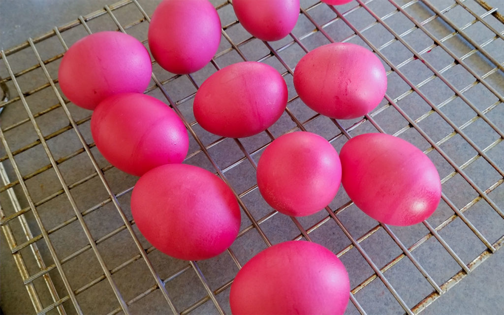 red dyed eggs on a cooking rack