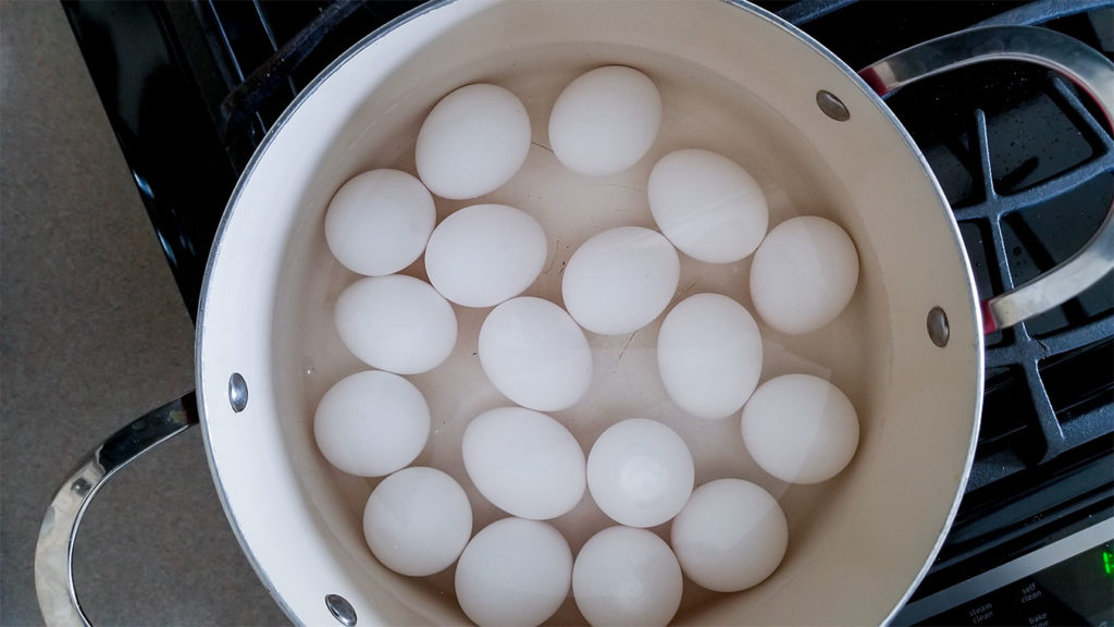 Eggs covered in water in a stockpot