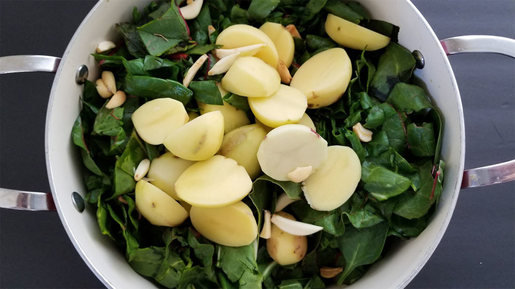 Swiss chard, potatoes and garlic in a stock pot