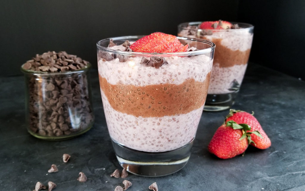 Strawberry Chocolate Chia Pudding in a cup alongside chocolate chips
