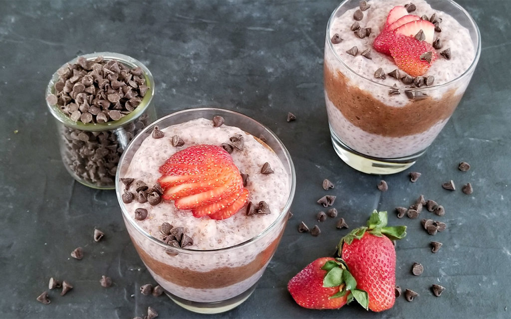 Strawberry Chocolate Chia Pudding in a cup alongside chocolate chips