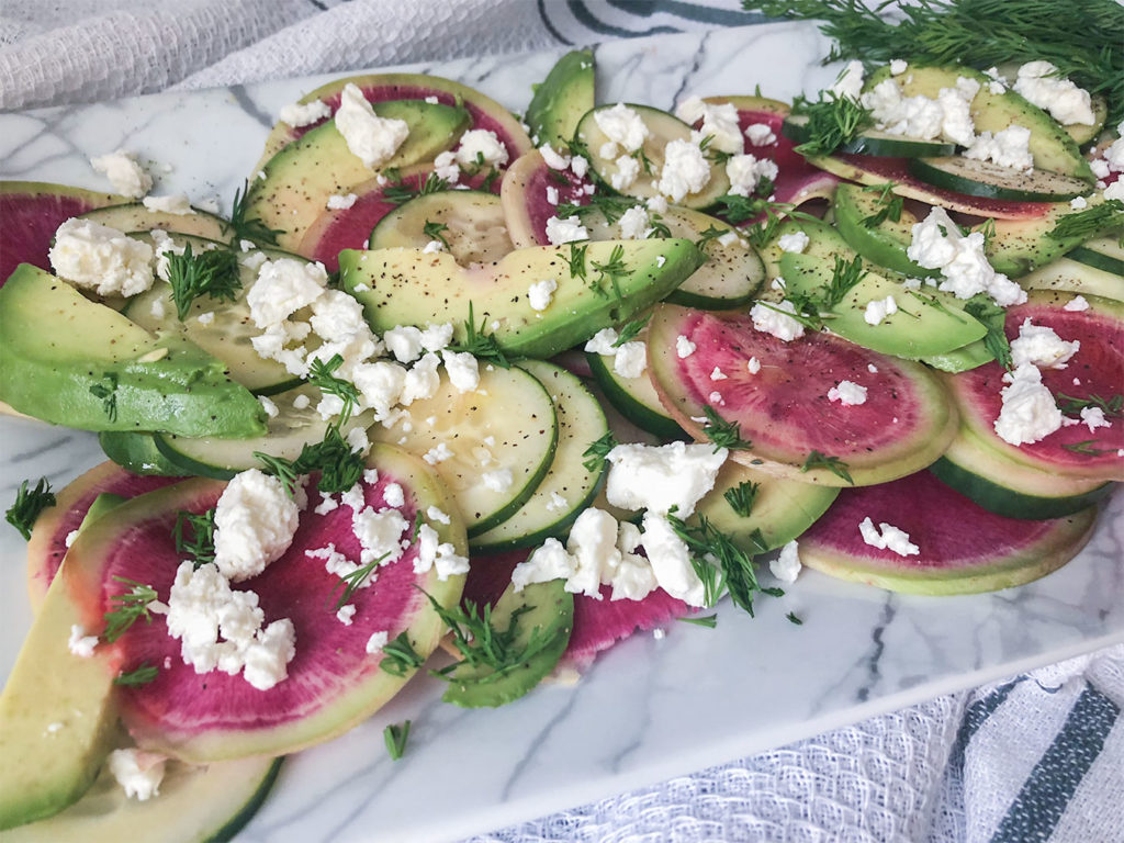 Watermelon Radish Salad topped with dill and feta cheese on a serving plate