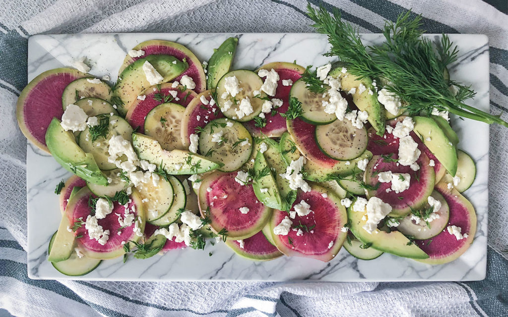 Watermelon Radish Salad topped with dill and feta cheese on a serving plate