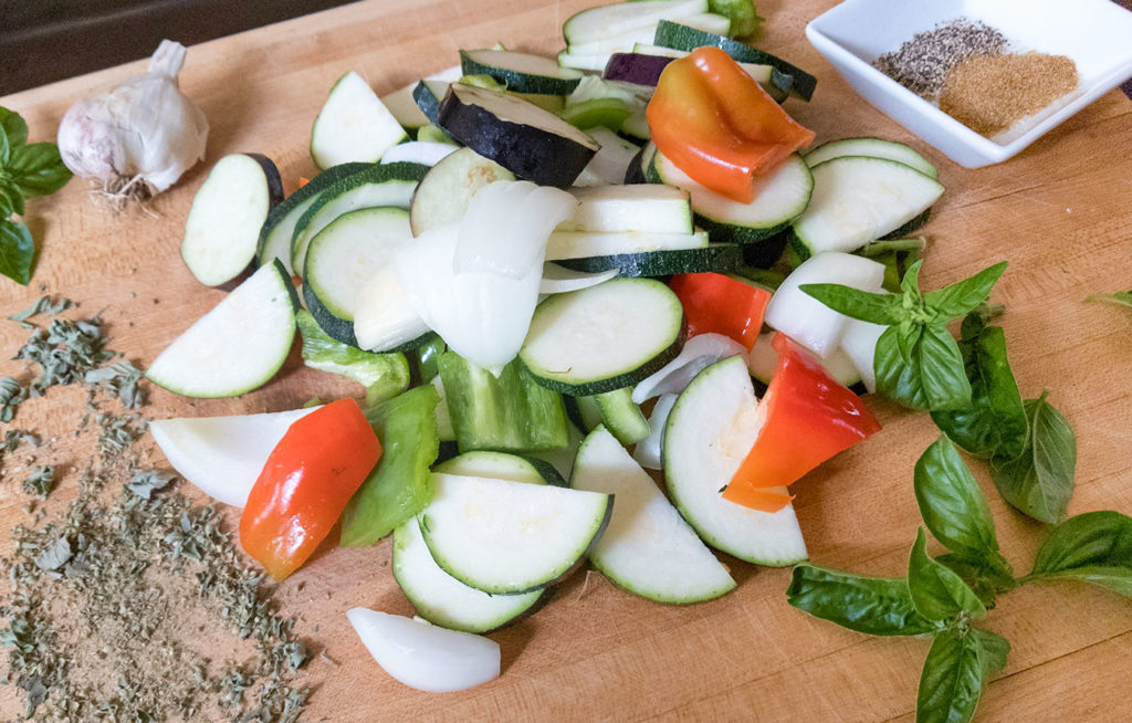 vegetables cut up on a butting board with spices