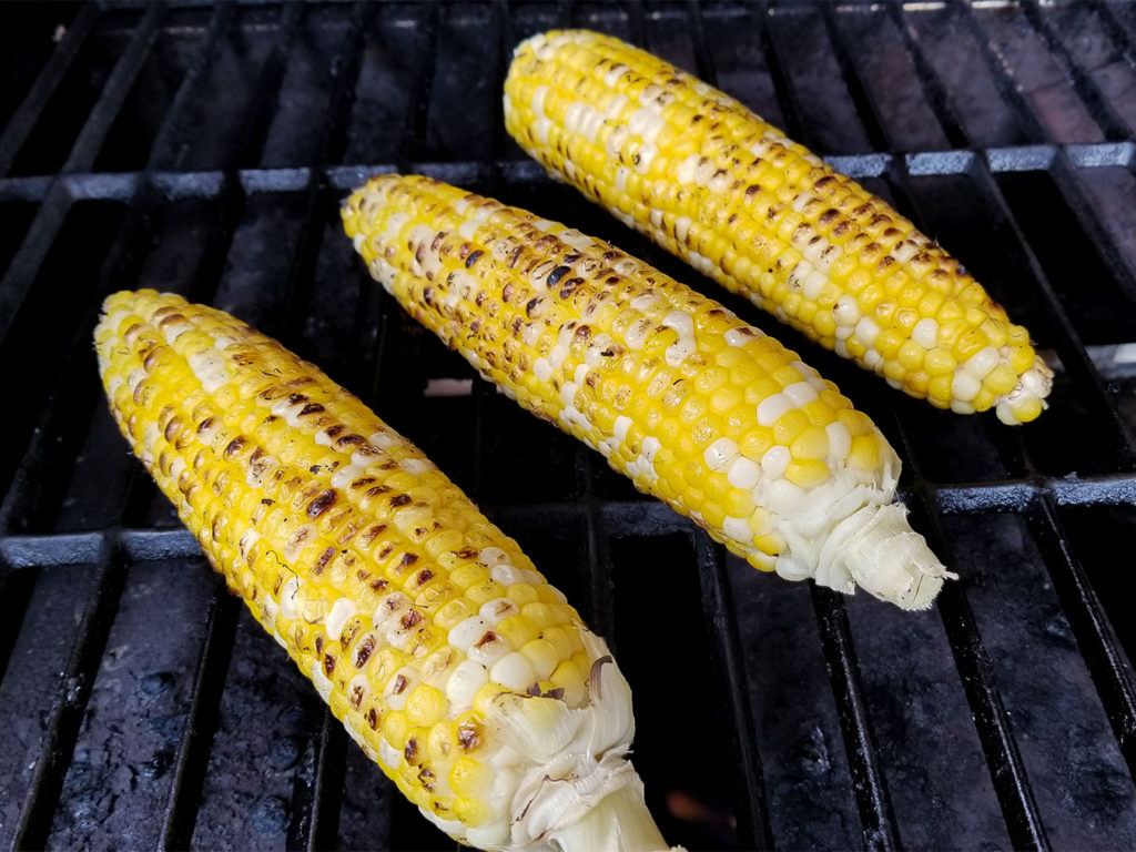 Corn on the cob cooking on a grilll