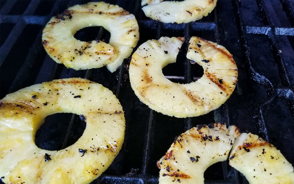 pineapple rings cooking on a grill