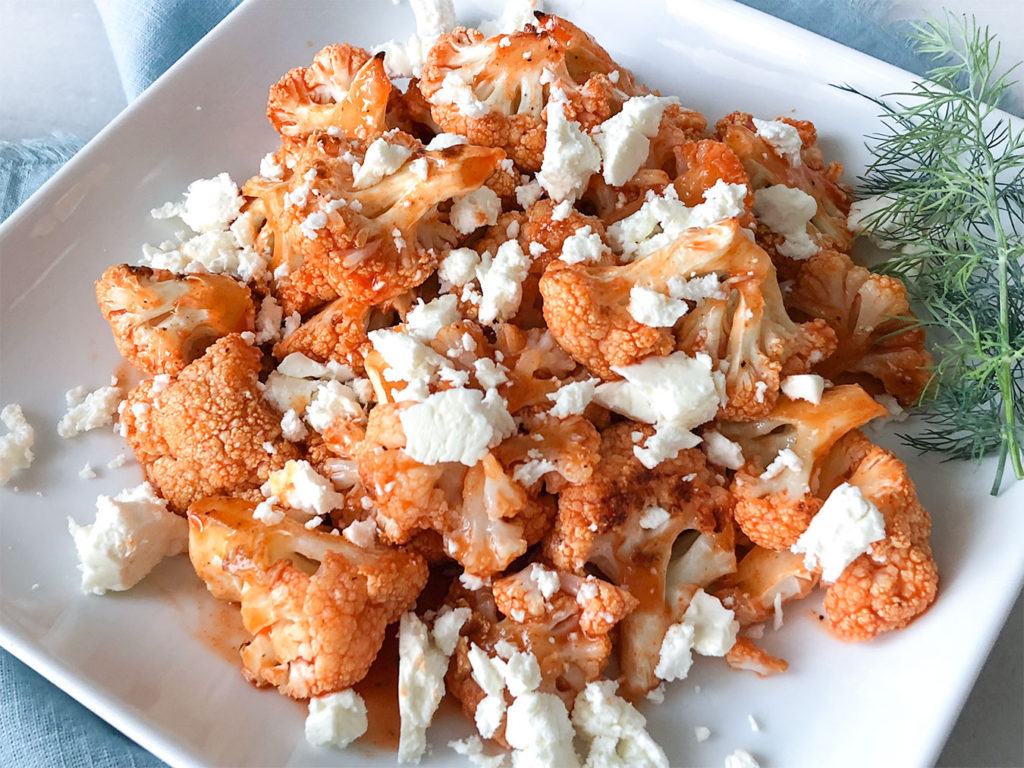 Buffalo Cauliflower on a plate topped with feta cheese
