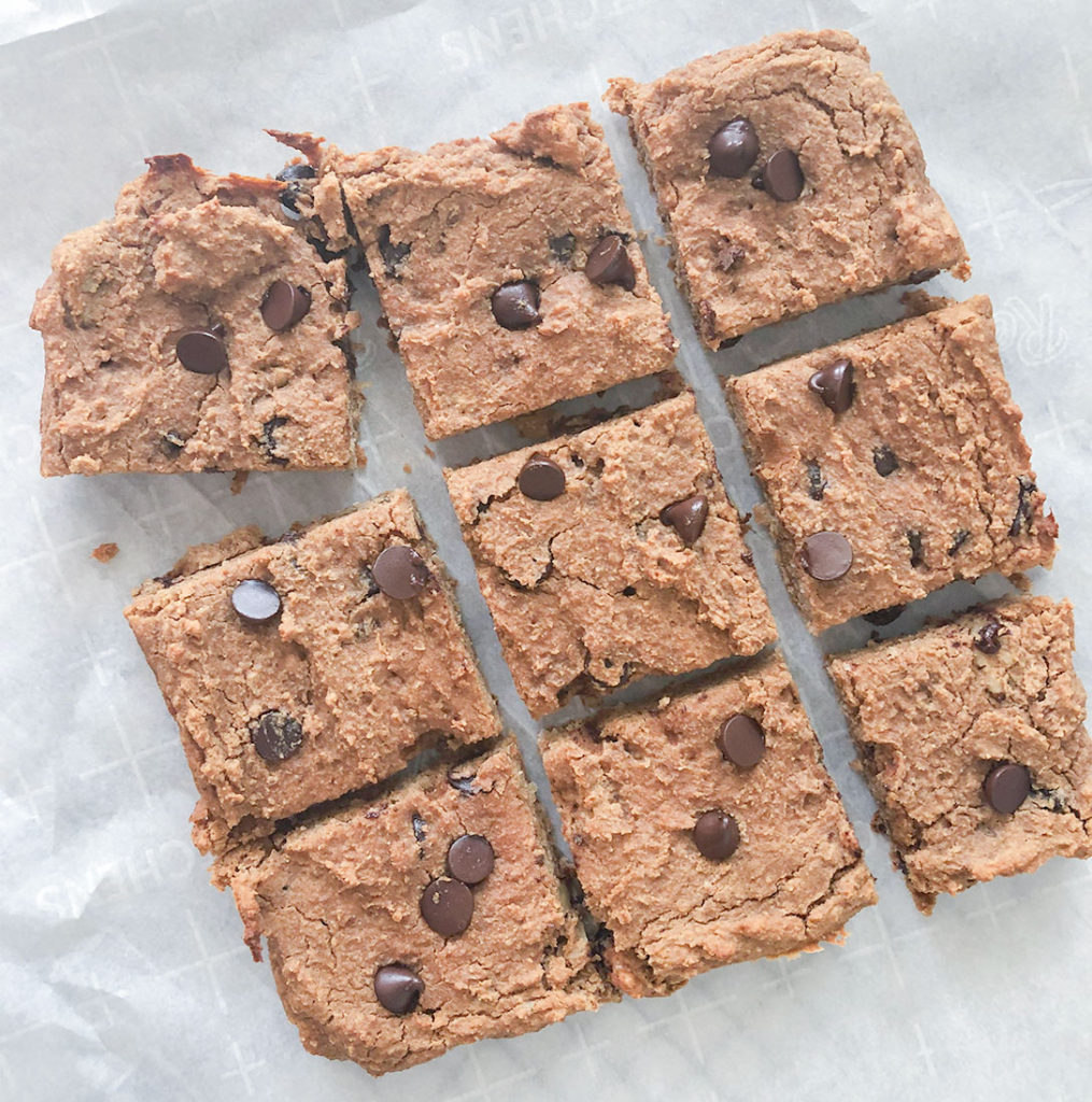 Chickpea Blondies cut into squares on parchment paper