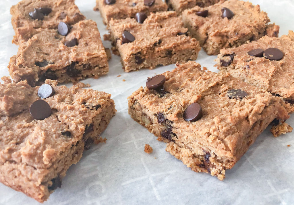 Chickpea Blondies cut into squares on parchment paper