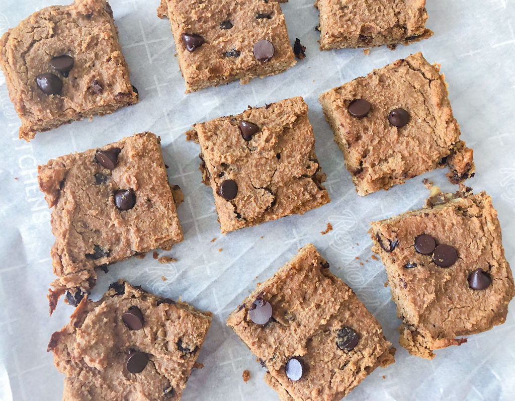 Chickpea Blondies cut into squares on parchment paper