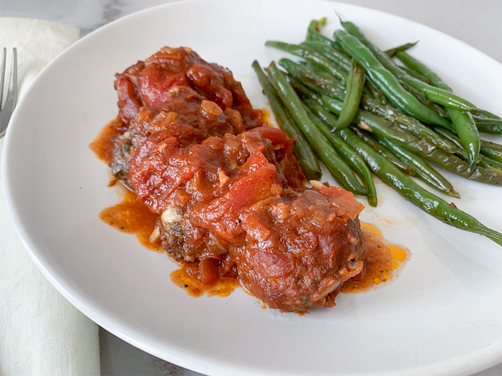 Greek Meatballs in Tomato Sauce with a side of green beans on a plate