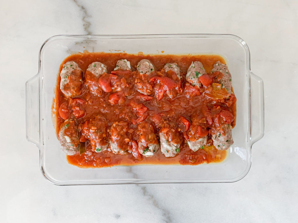 Meatballs covered in the tomato sauce and ready to go in the oven
