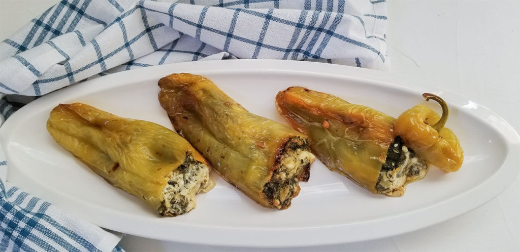 cooked spanakopita stuffed peppers on a serving pate