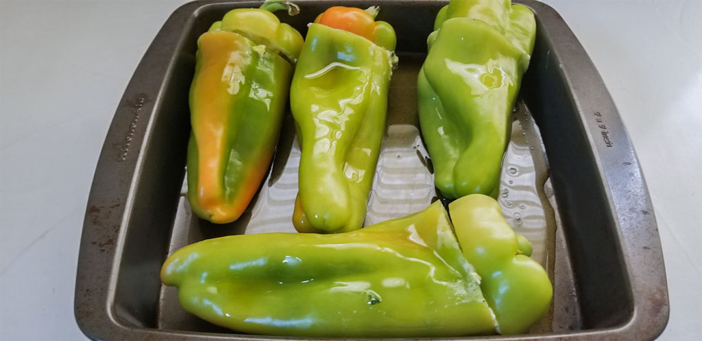 peppers stuffed in a pan with olive oil before baking
