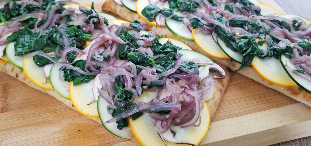 focaccia bread with layers of squash, mushrooms, sautéed onion and spinach