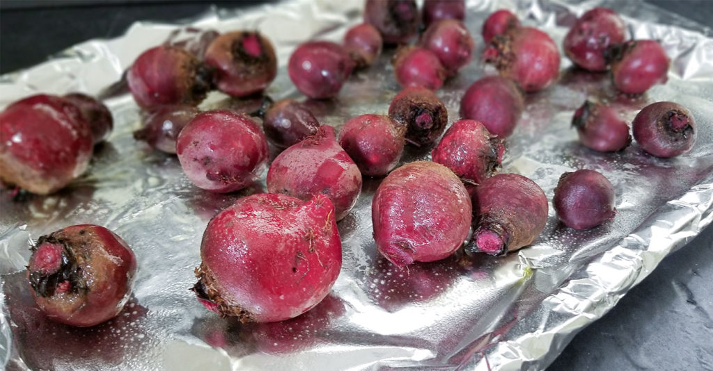 whole beets on an aluminum foil lined baking sheet