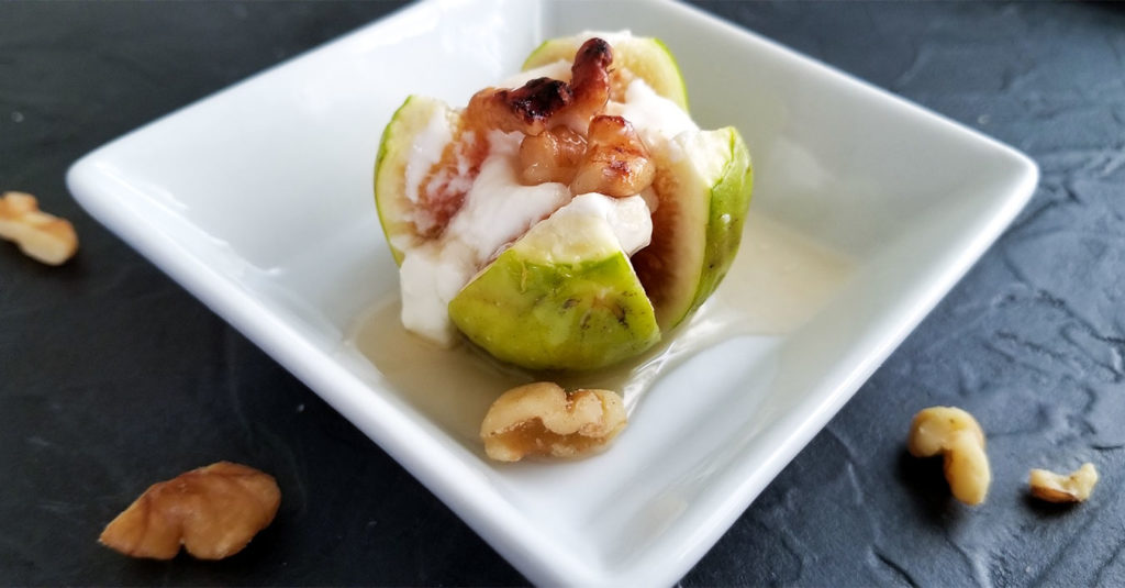 Stuffed fig on a plate with walnuts