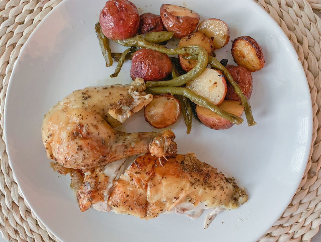 chicken breast and leg on a plate with potatoes and green beans