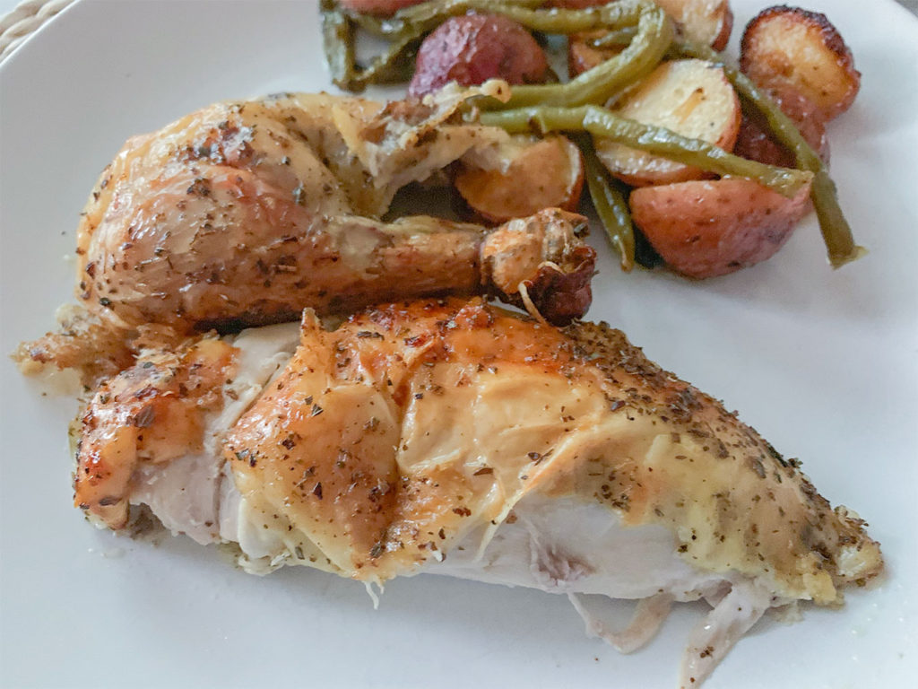 chicken breast and leg on a plate with potatoes and green beans