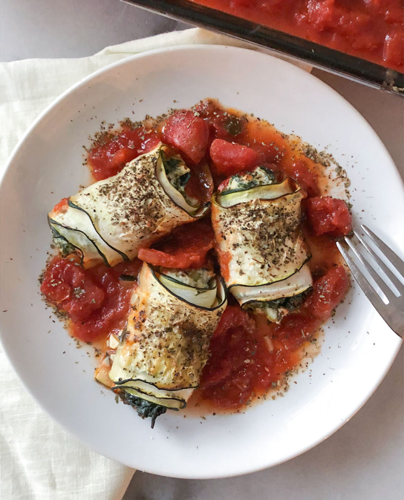 Spanakopita Stuffed Zucchini Roll-Ups on a plate topped with oregano