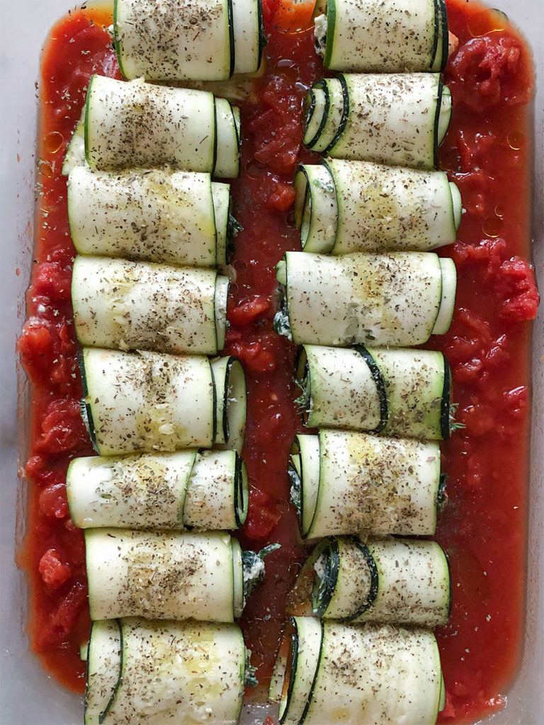 Spanakopita Stuffed Zucchini Roll-Ups in a baking dish before going into the oven
