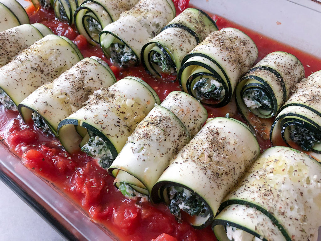 Spanakopita Stuffed Zucchini Roll-Ups in a baking dish before going into the oven