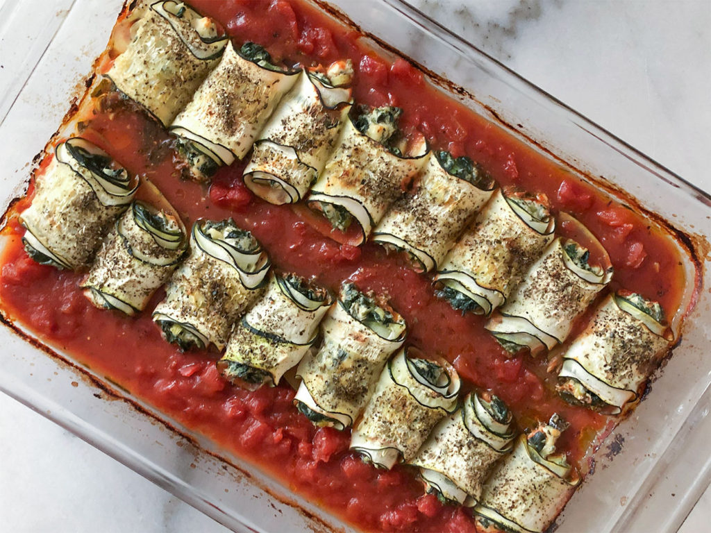 Spanakopita Stuffed Zucchini Roll-Ups in a baking dish