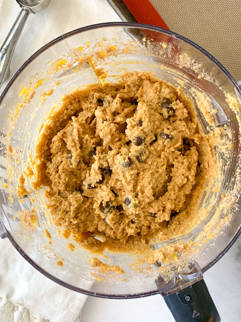 pumpkin cookie batter in a food processor with chocolate chips