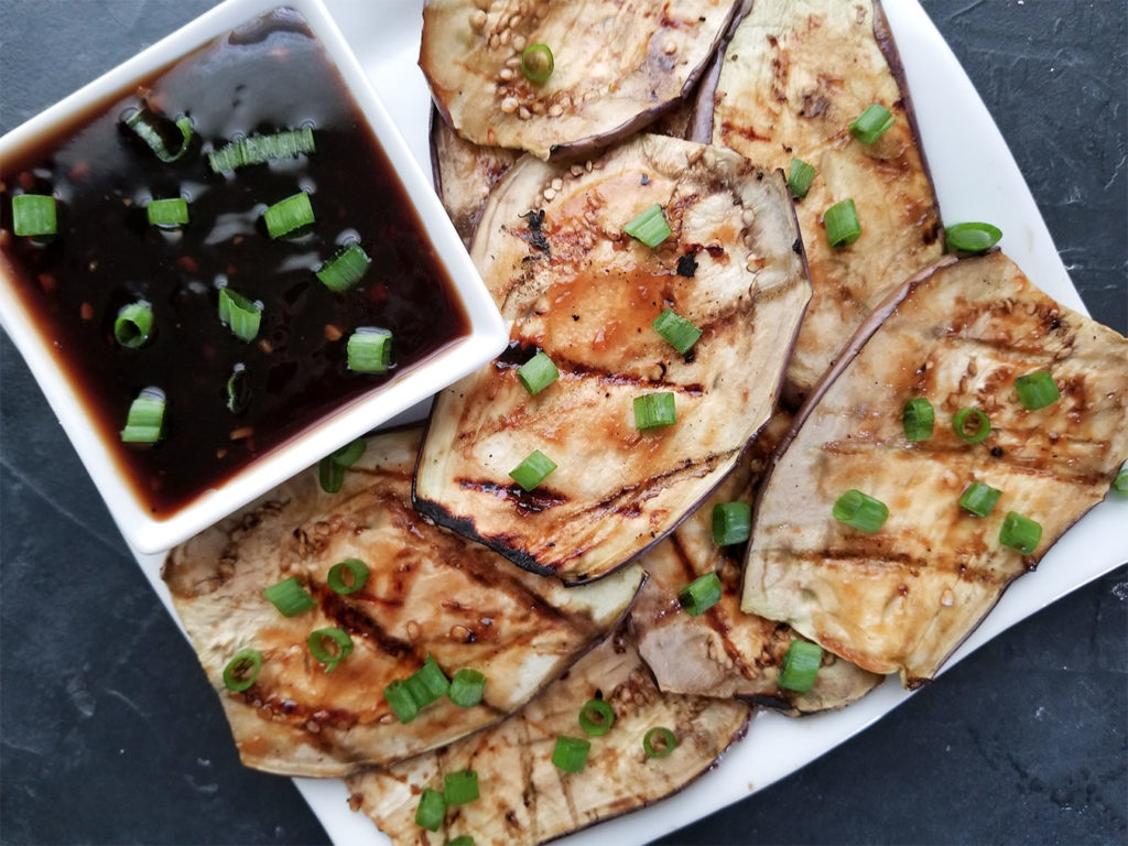 Grilled Eggplant on a plate with dipping sauce