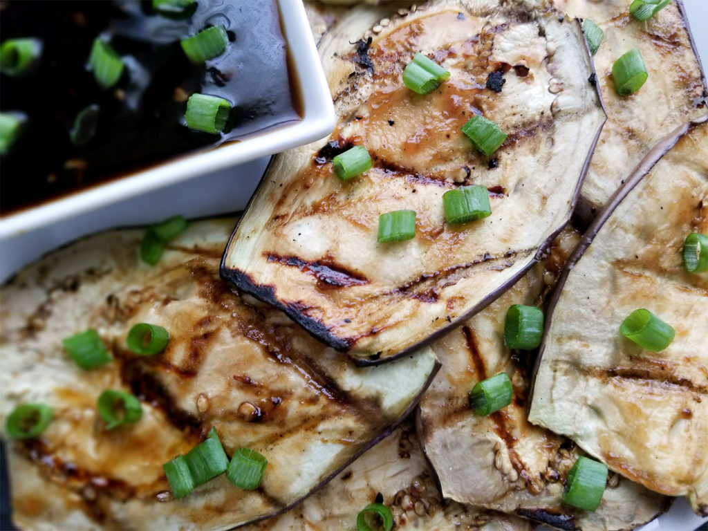 Grilled Eggplant on a plate with dipping sauce