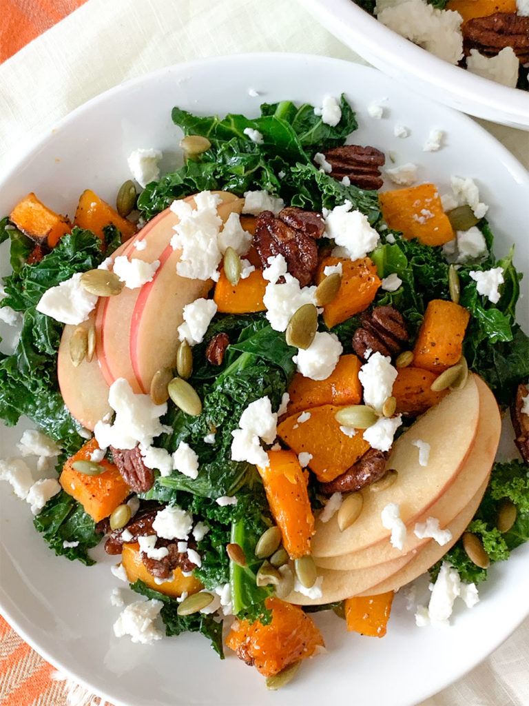 Warm Kale Salad with apples, pecans, feta cheese on a plate