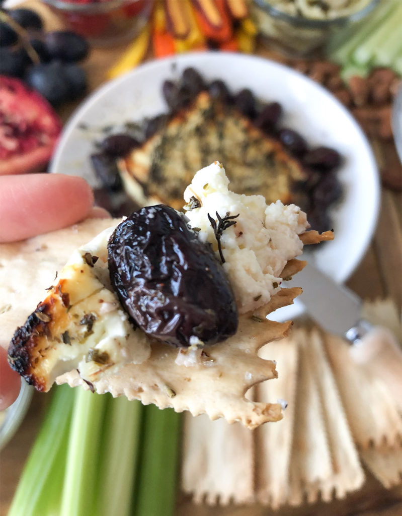 Baked feta and kalamata olive on a cracker