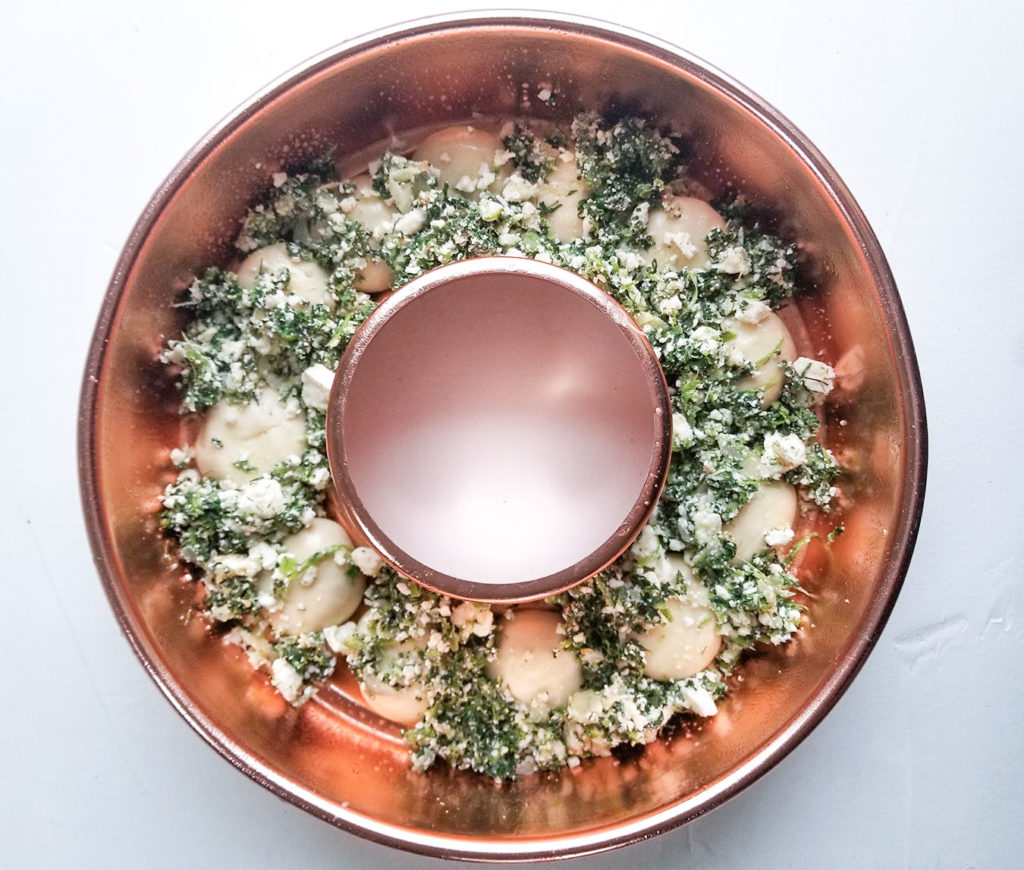 spanakopita filling and bread dough in a bundt pan