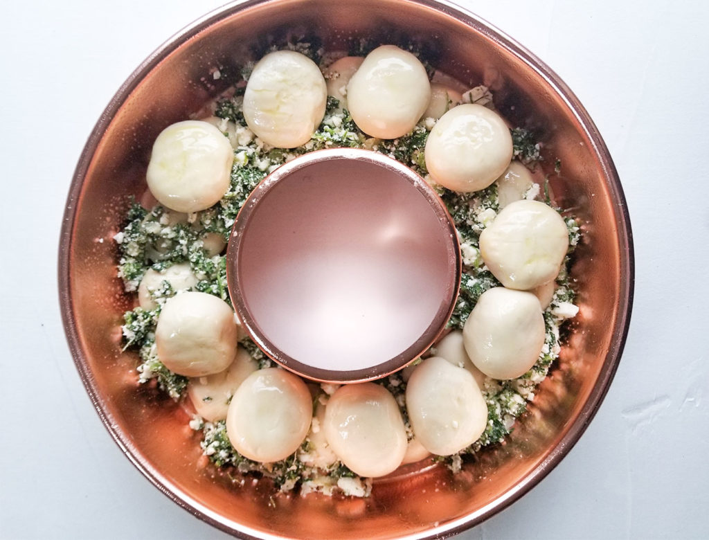 spanakopita filling and bread dough in a bundt pan