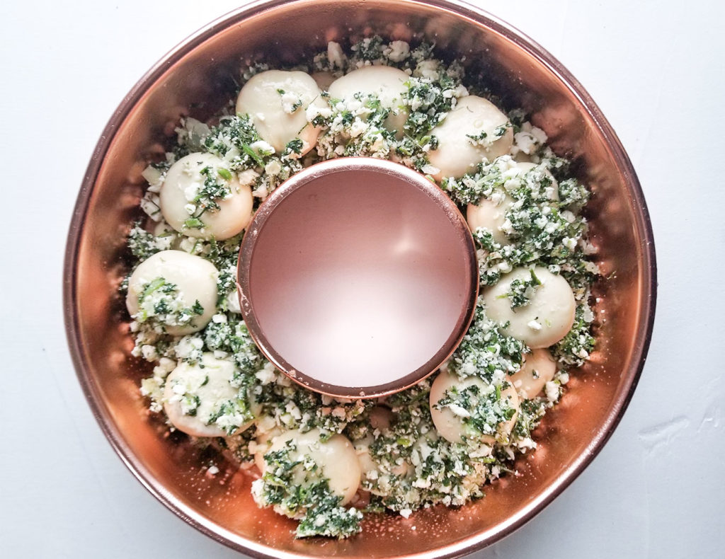 spanakopita filling and bread dough in a bundt pan