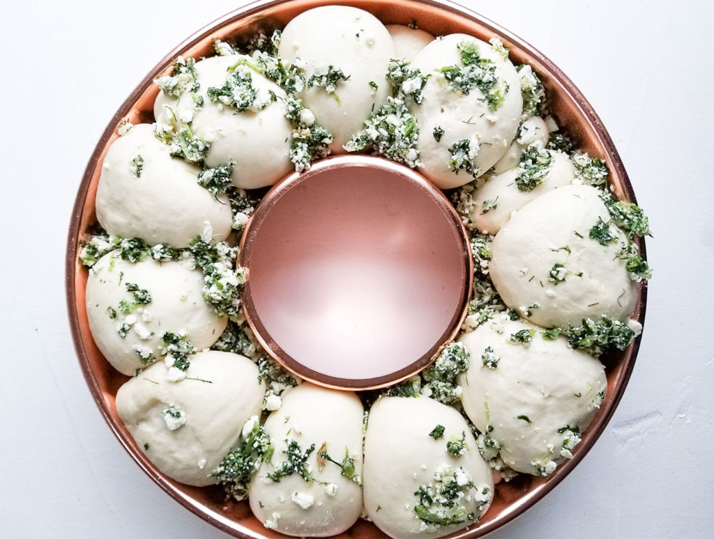 spanakopita filling and bread dough in a bundt pan