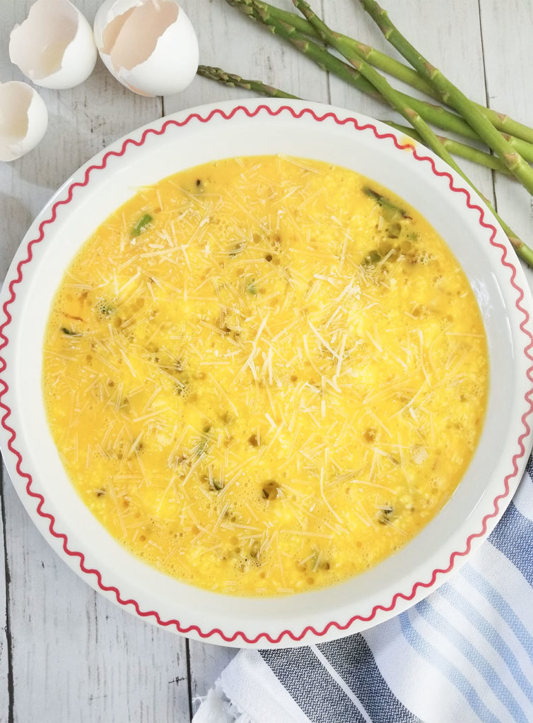 Asparagus and feta quiche egg mixture in a pan