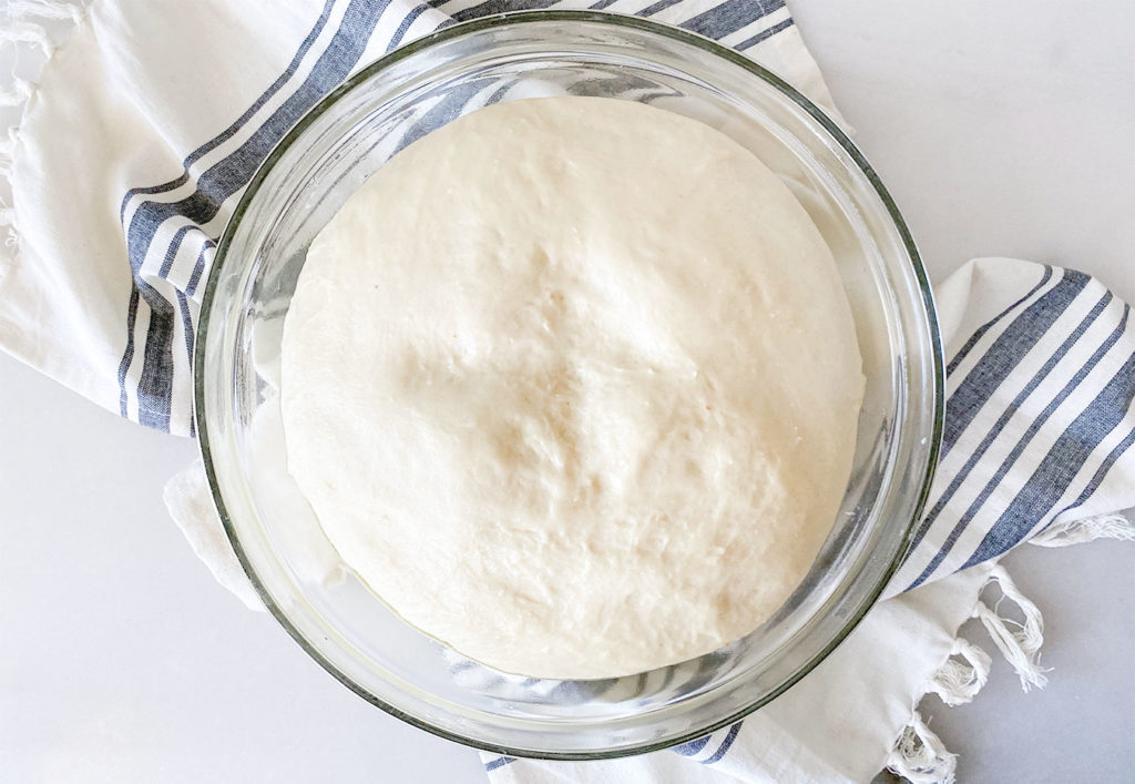 tsoureki dough risen in a bowl with olive oil