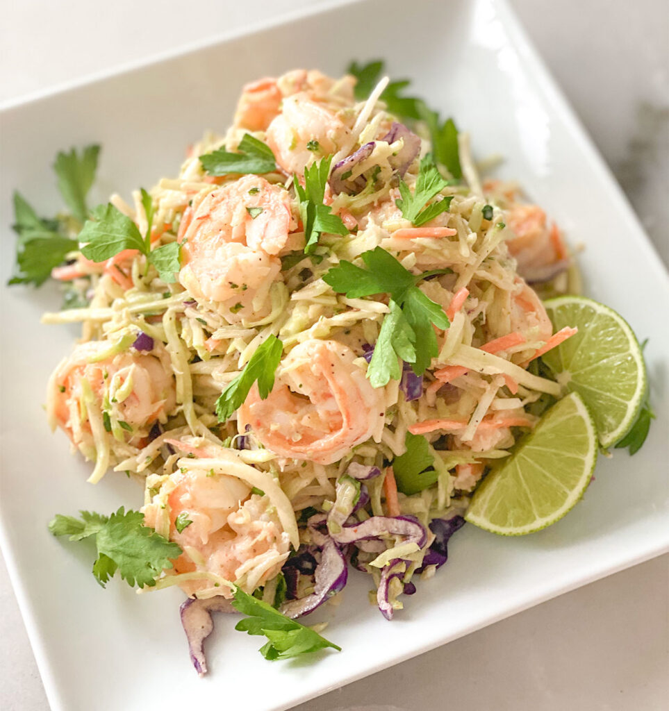 bang bang shrimp salad on a plate with lime